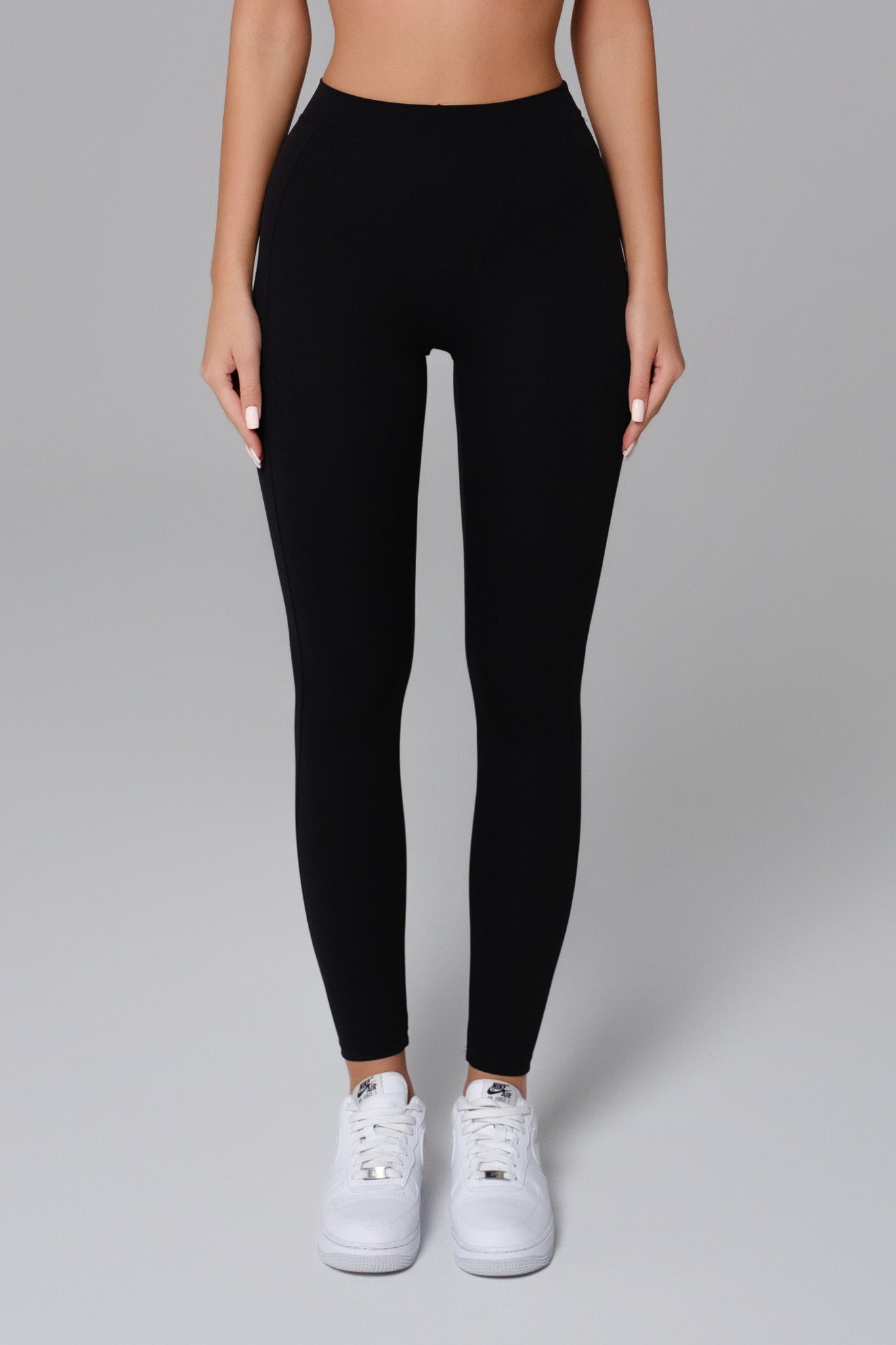 Black Maison and Aurora Essential High Waist Sculpting Leggings laid flat, showing their stretchy, figure-enhancing design.