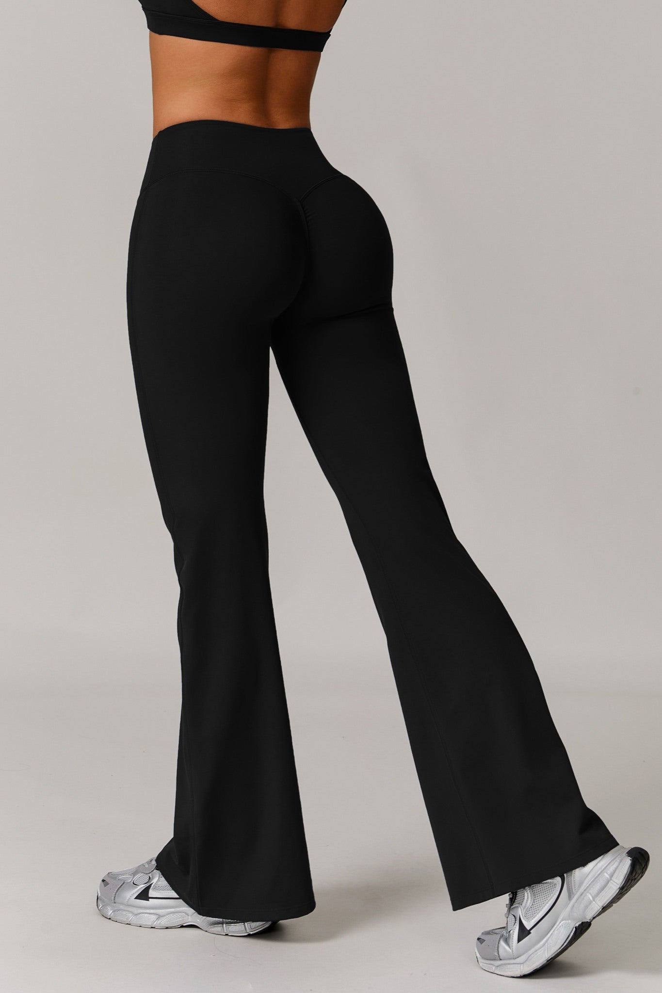 Black Maison and Aurora Infinity Flare Leggings showing the fitted waistband and flared leg design on a model.