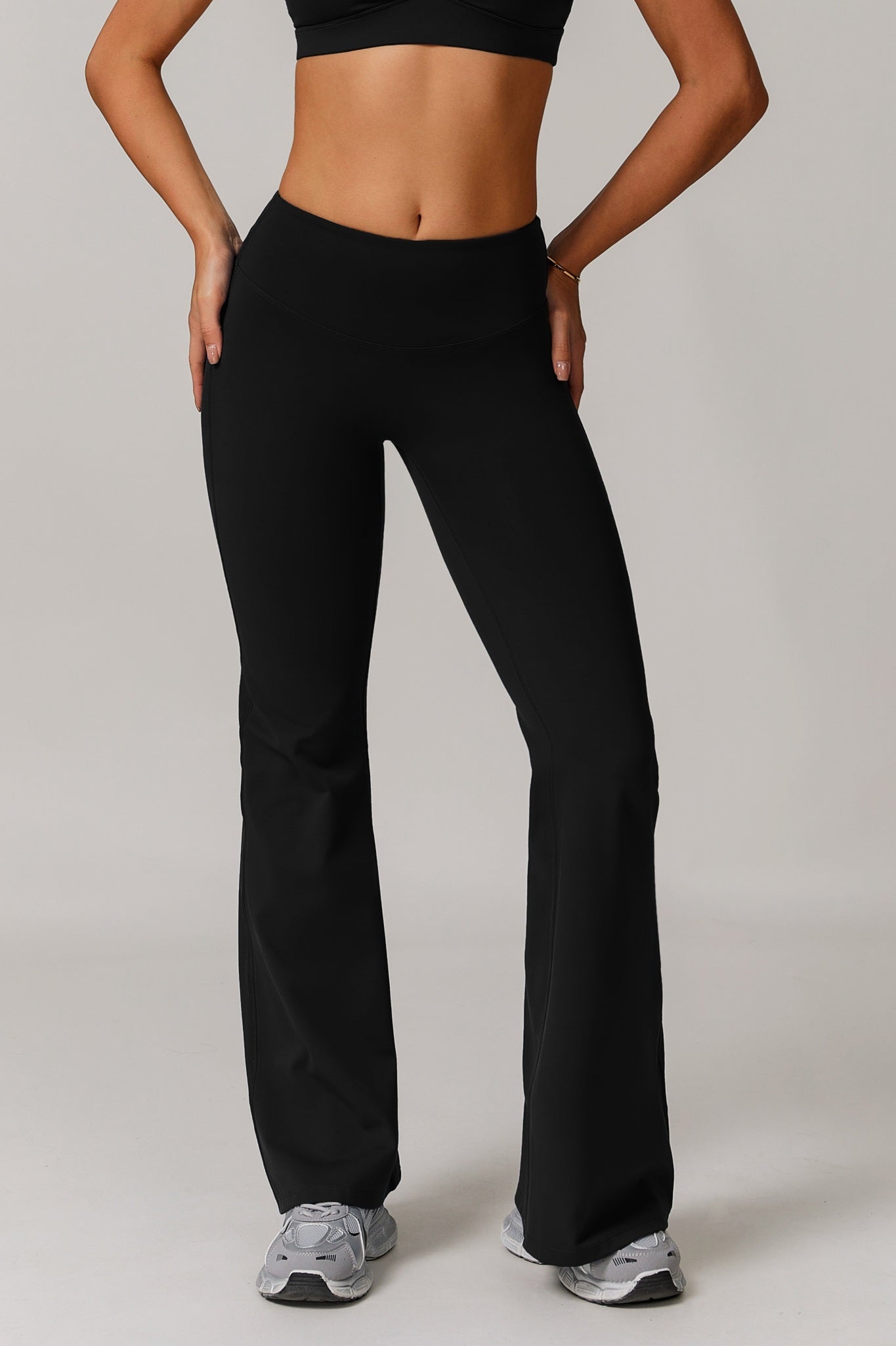 Black Infinity Flare Leggings by Maison and Aurora showing the fitted waistband and flared leg design on a model.
