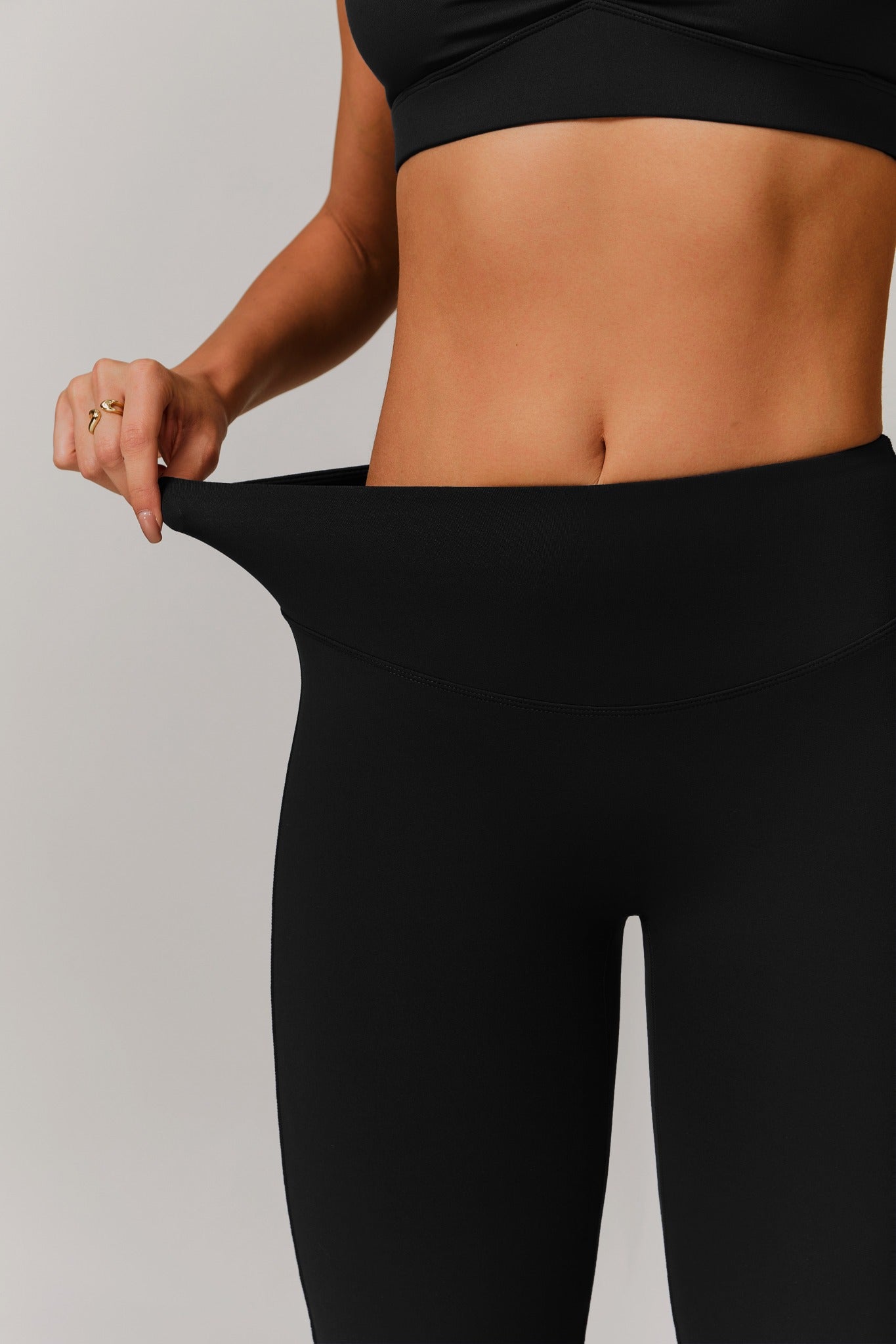 Black Maison and Aurora Infinity Flare Leggings with a fitted waist and flared legs, shown on a model.