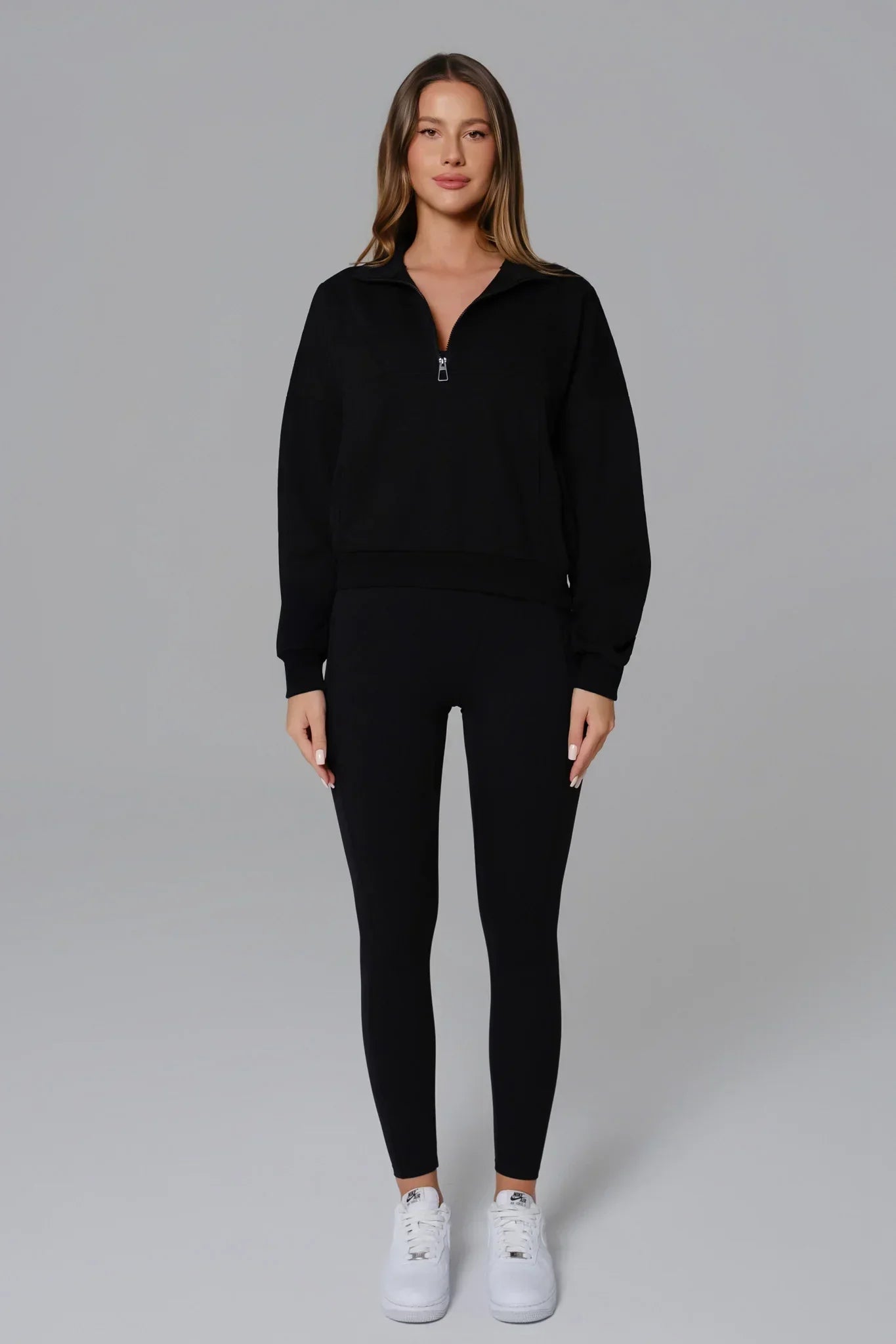 Black Maison and Aurora Essential open-back jumpsuit displayed on a model, showcasing its sleek design and stylish fit.