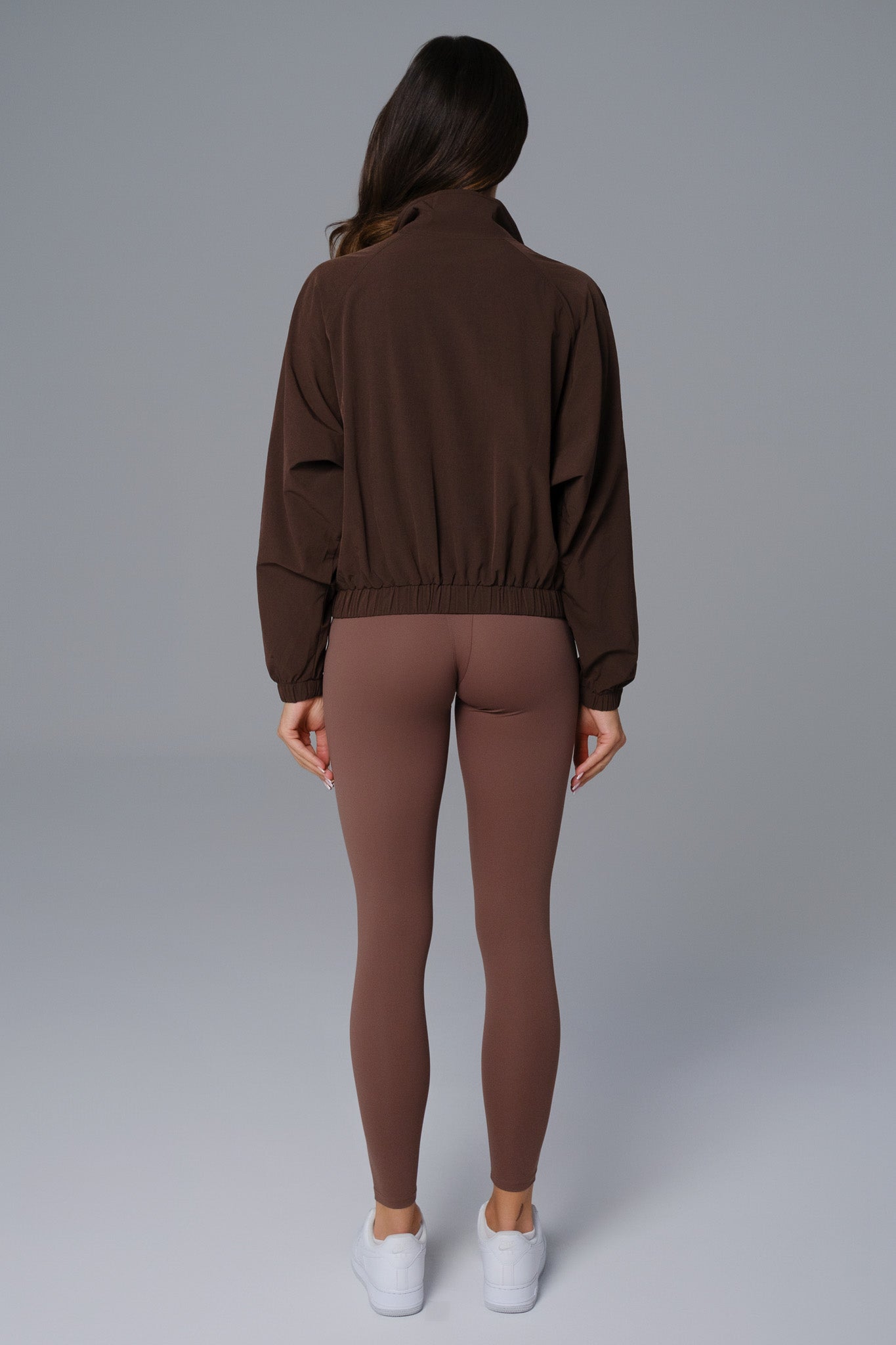 Maison and Aurora Ava cropped windbreaker jacket in russet brown, shown as a stylish lightweight top with a zip front and hood.