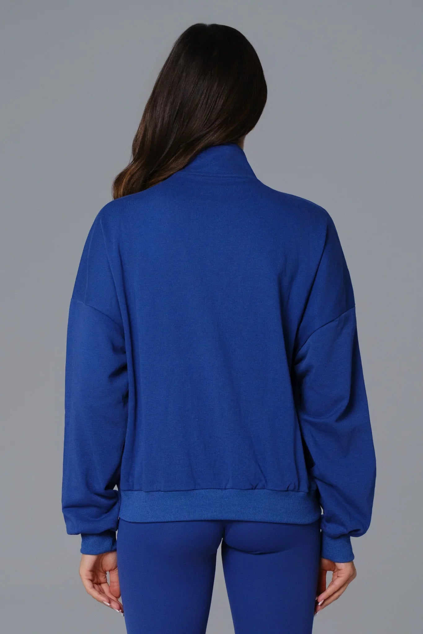 Maison and Aurora sapphire blue half-zip sweatshirt, casual top with a stand-up collar and relaxed fit, displayed on a hanger.